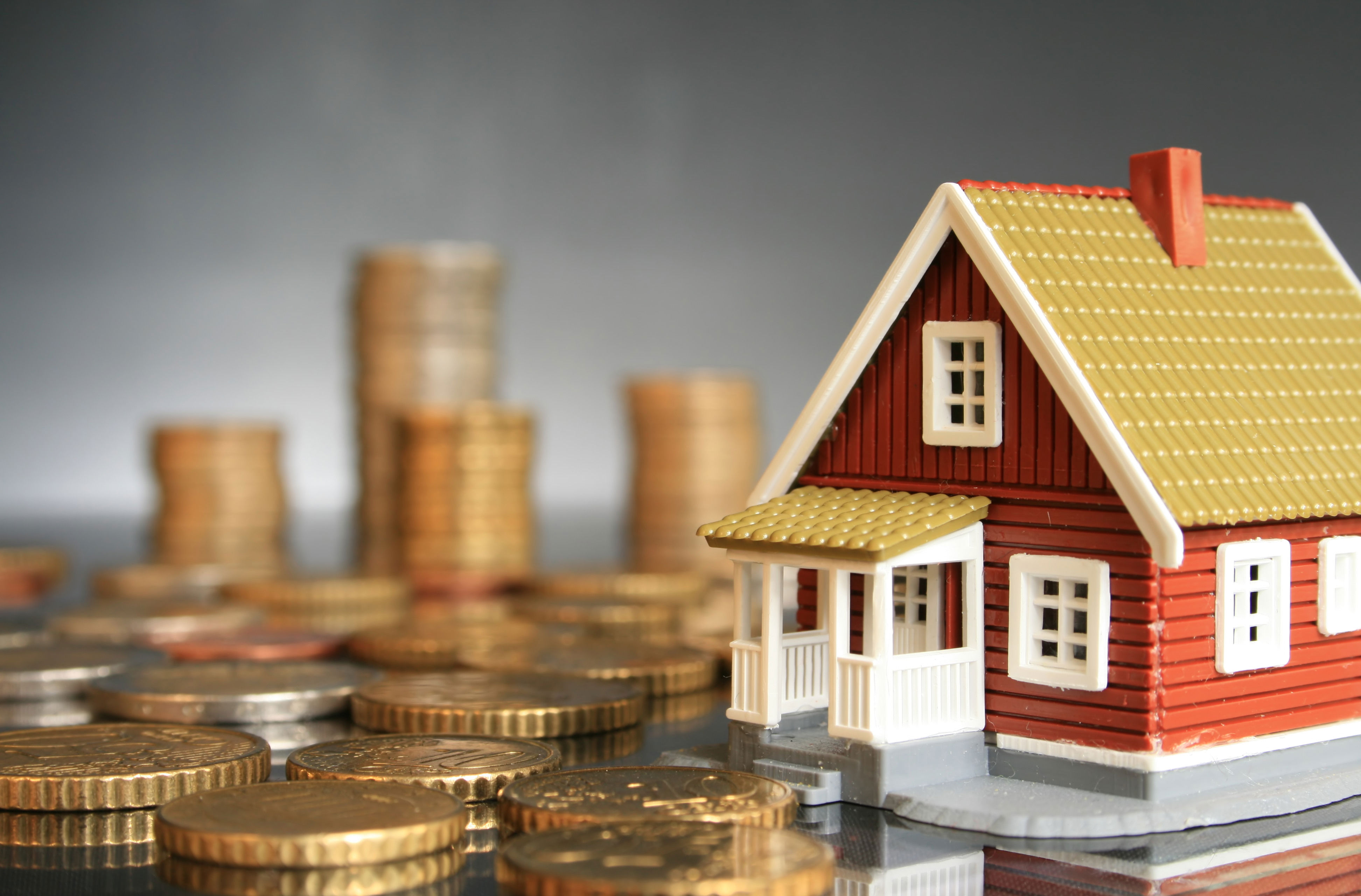 Billede af legetøjshus med store mønter omkring