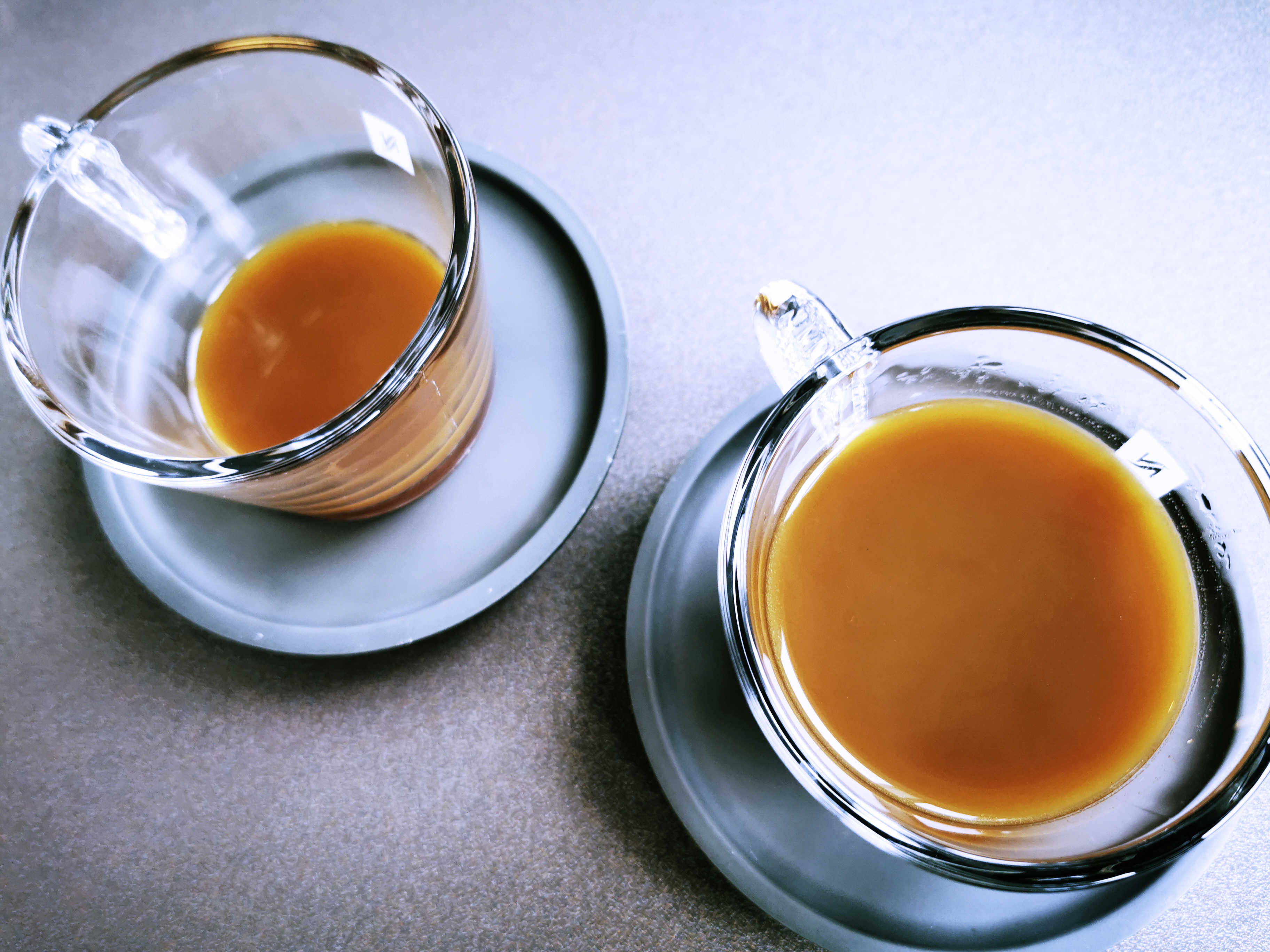 To kopper kaffe i glaskopper. Kaffen er lys - måske med mælk?